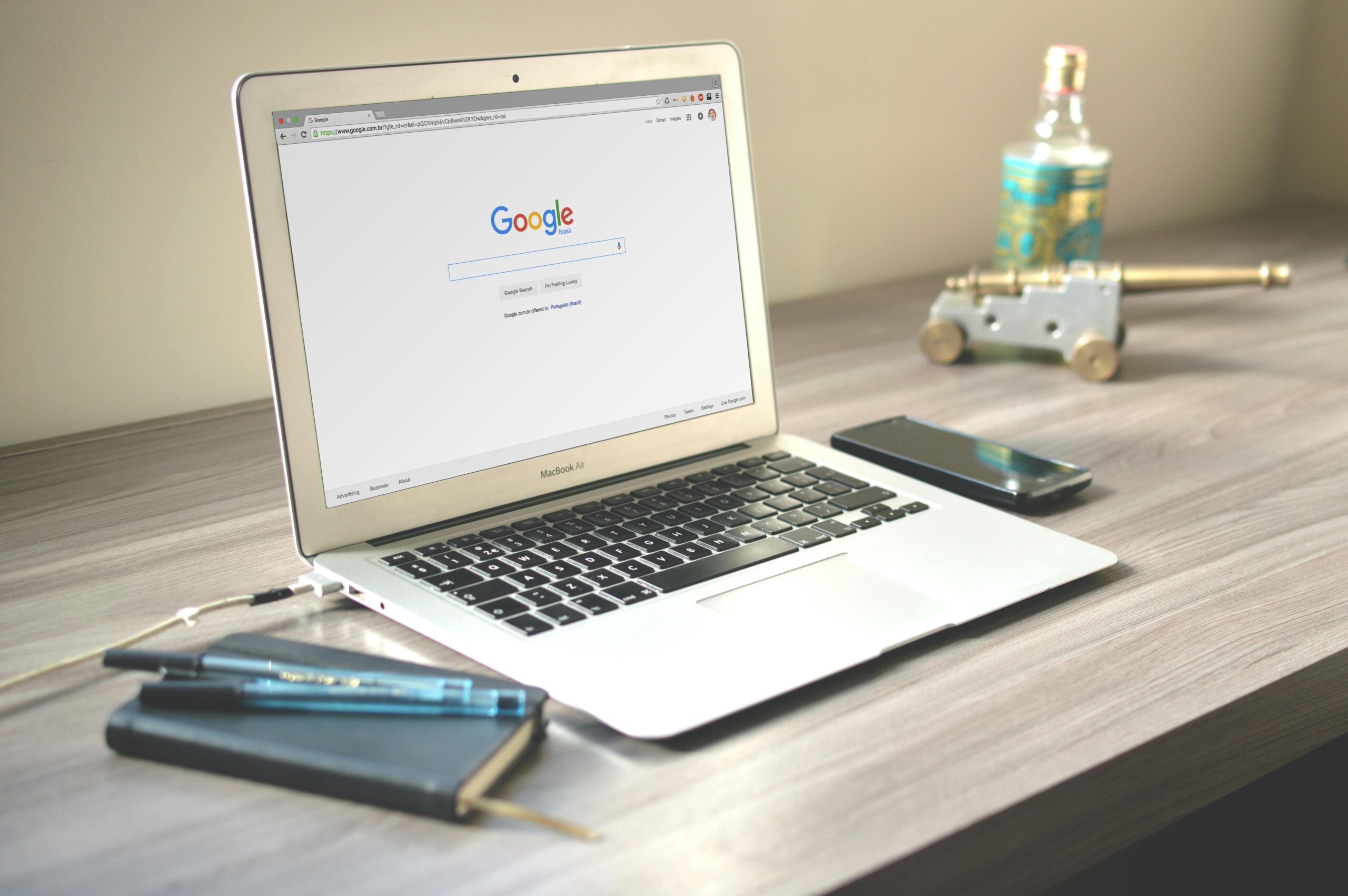 A laptop sitting on a desk with the Google search page visible on the screen.