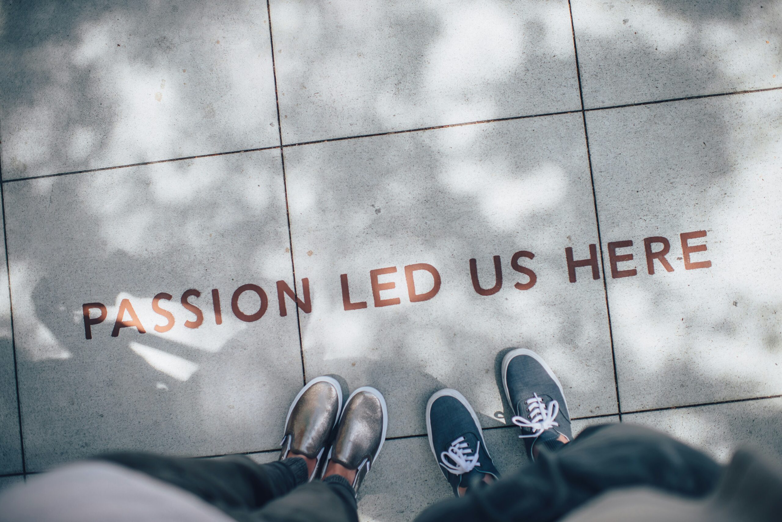 Two people standing on inspirational sidewalk quote