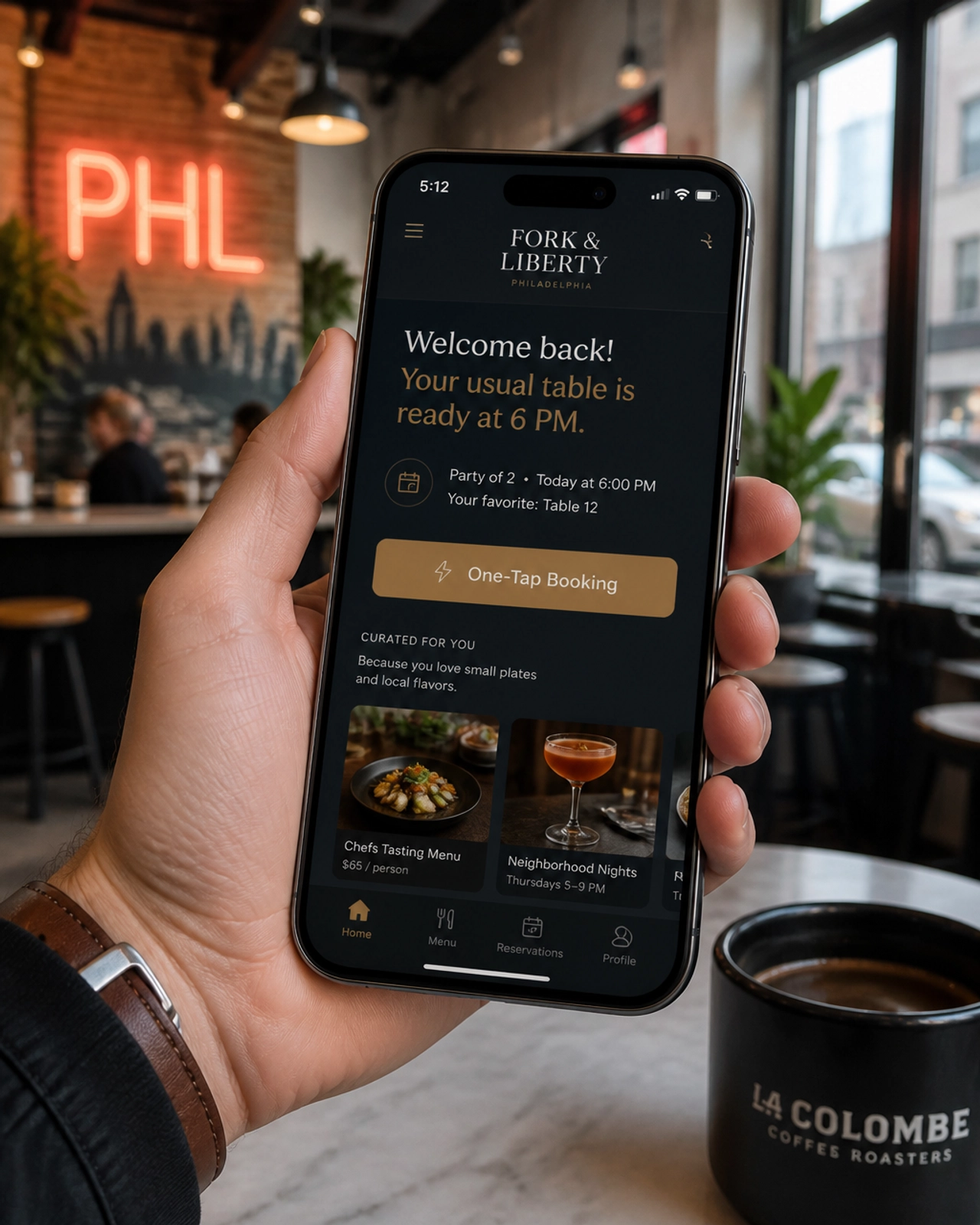 A person in a Philadelphia coffee shop holding a smartphone with an adaptive, personalized business website